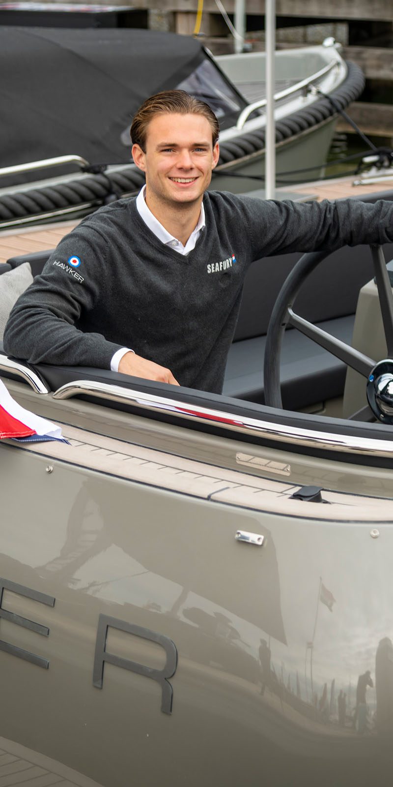 student van iva nautische opleiding zit in jacht en kijkt in camera